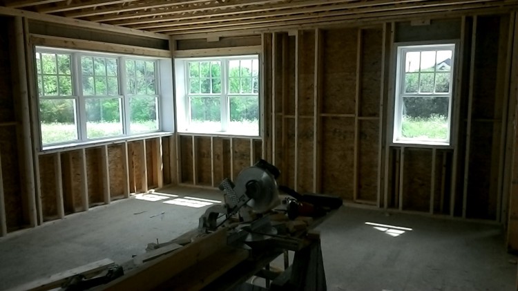 The window on the right has a 2x4 frame around it. The windows on the left... not yet.
